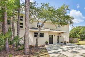 A two-story house with a front porch, a driveway, and a fenced backyard. - Tampa North Aero Park Townhome: Near Downtown! (Lutz)