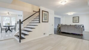 Ein modernes Interieur mit Treppe, Essbereich und Wohnbereich.