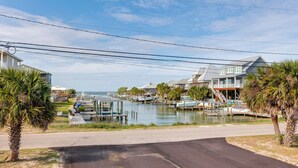 A marina with boats, waterfront houses, and a road leading to the water. - Walk to Beach! Waterfront Beach House w/ Deck (Dauphin Island)