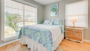 A bedroom with a bed, a dresser, and a ceiling fan. - Walk to Beach! Waterfront Beach House w/ Deck (Dauphin Island)