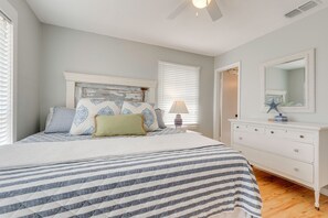A bedroom with a bed, dresser, and a mirror. - Walk to Beach! Waterfront Beach House w/ Deck (Dauphin Island)
