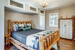 A bedroom with a wooden bed frame, a bench, a wardrobe, and a window. - 3 Mi to Lake George & Village: Family Home w/ Deck (Lake George)