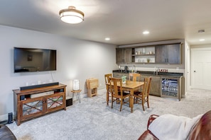 A compact living space with a dining area, kitchen, and a television mounted on the wall. - Next to Public Golf Course! Kalispell Townhome (Kalispell)