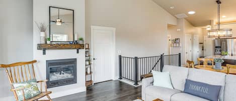A living room with a fireplace, a rocking chair, a sofa, and a dining area.