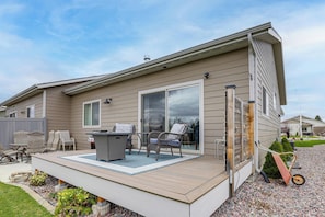 A residential deck with outdoor furniture, a sliding glass door, and a wheelbarrow. - Next to Public Golf Course! Kalispell Townhome (Kalispell)