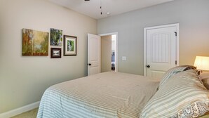 Une chambre à coucher avec un lit, un ventilateur de plafond et deux portes.
