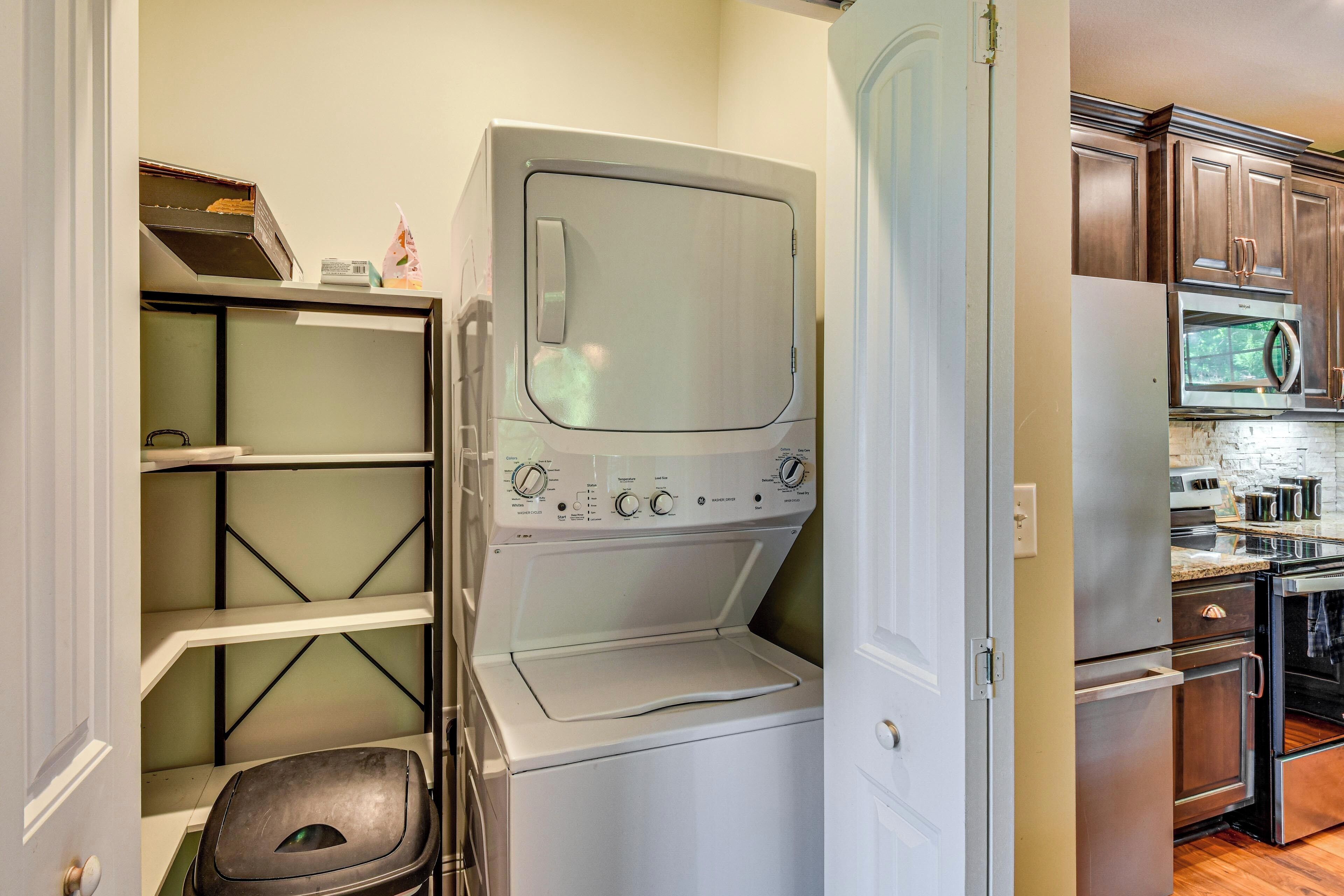 A laundry room with a washer and dryer, a microwave, and a stove.