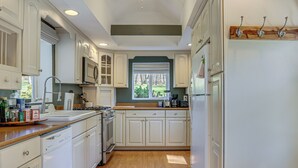 A kitchen with white cabinets, a stove, and a dishwasher.