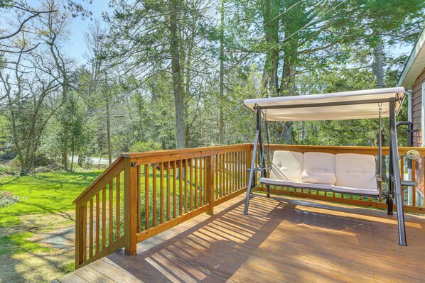 A wooden deck with a swing chair and a canopy, surrounded by trees. - Tranquil Catskills Home w/ Creek & Fire Pits (Parksville)