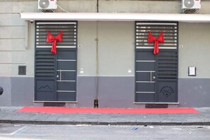 A building with two doors, each with a red bow, and a red carpet in front. - WITHIN WALKING DISTANCE OF CENTRAL STATION AND NAPLES BUSINESS CENTER. (Napoli)