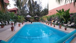 A swimming pool with lounge chairs and potted plants around it. - Fana Hotel (Dakar)