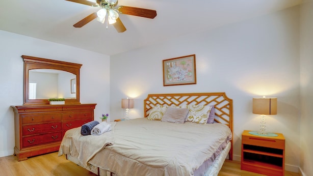 A bedroom with a bed, dresser, nightstand, lamp, ceiling fan, and a framed picture on the wall. - Family-friendly Home 7 Mi to Dtwn San Bernardino! (Rialto)