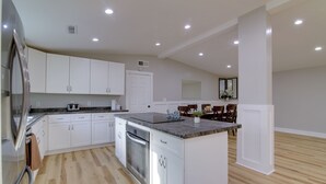 A modern kitchen with white cabinets, a granite countertop, and stainless steel appliances. - Huge 3-unit Commerce Estate Near ATL Dragway! (Commerce)
