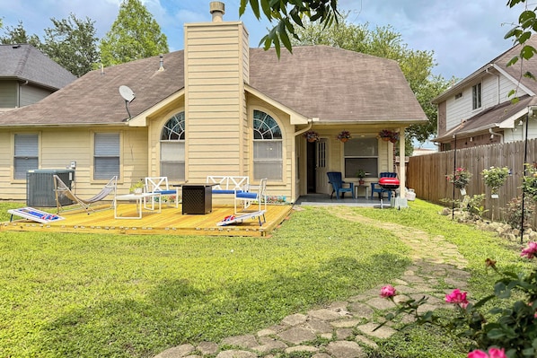 A house with a covered patio, a chimney, and a fenced backyard.