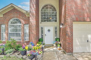 A brick house with a white garage door, a front door with a wreath, and a large arched window above the door. - Fun for All Ages! Spacious Home in Richmond (Richmond)