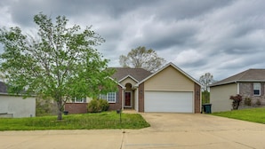 A residential house with a garage, a driveway, and a lawn.