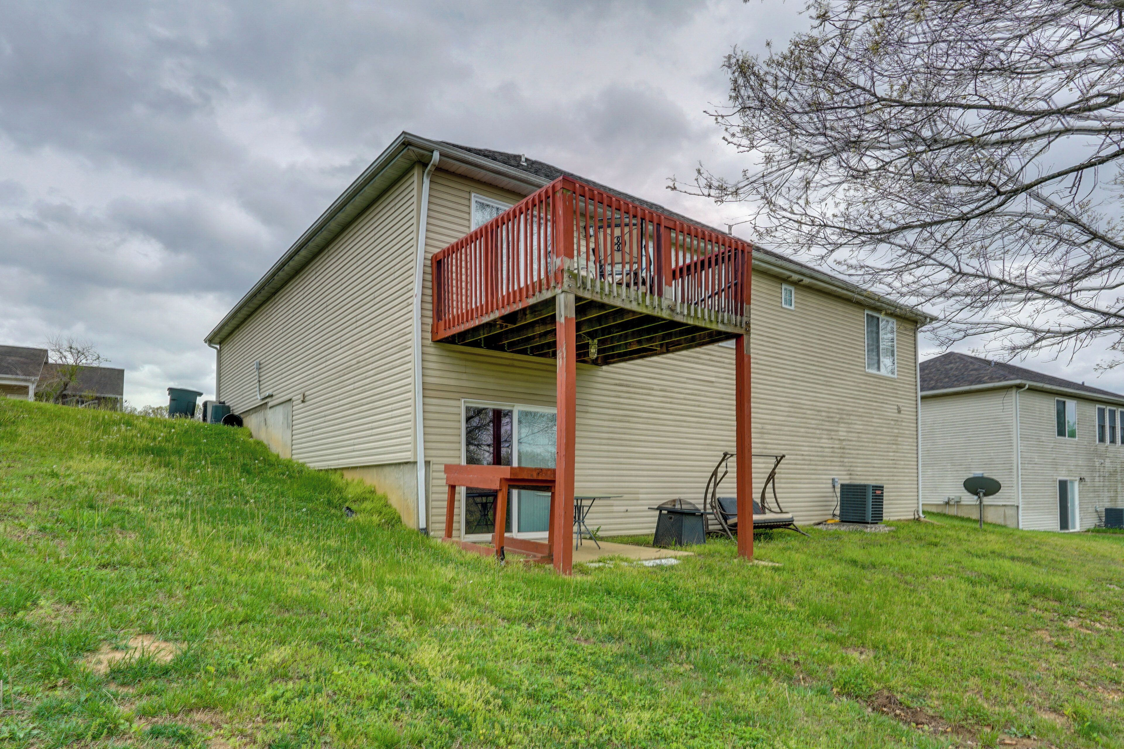 A two-story house with a covered patio area, a small deck, and a satellite dish.
