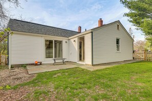 A single-story house with a covered patio, a small garden, and a wooden fence.