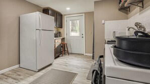 Una cocina compacta con refrigerador, estufa y gabinetes de madera.
