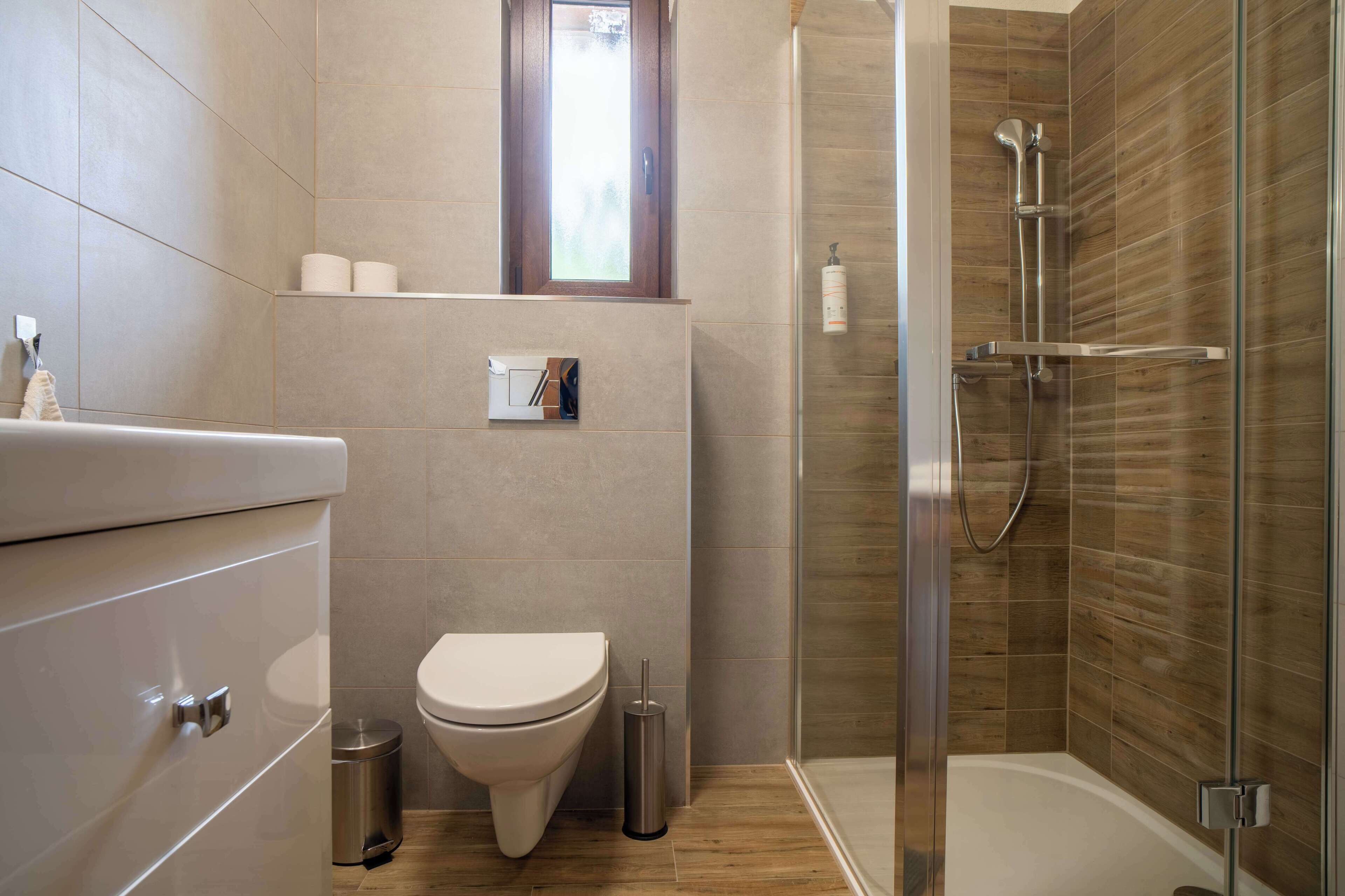 Un baño moderno con inodoro, bidé y ducha.