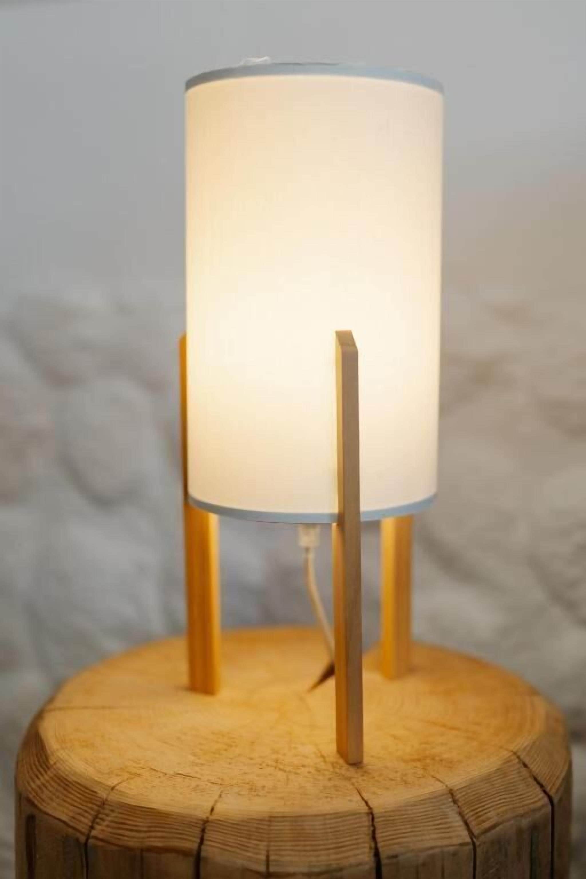 A lamp on a wooden stump.