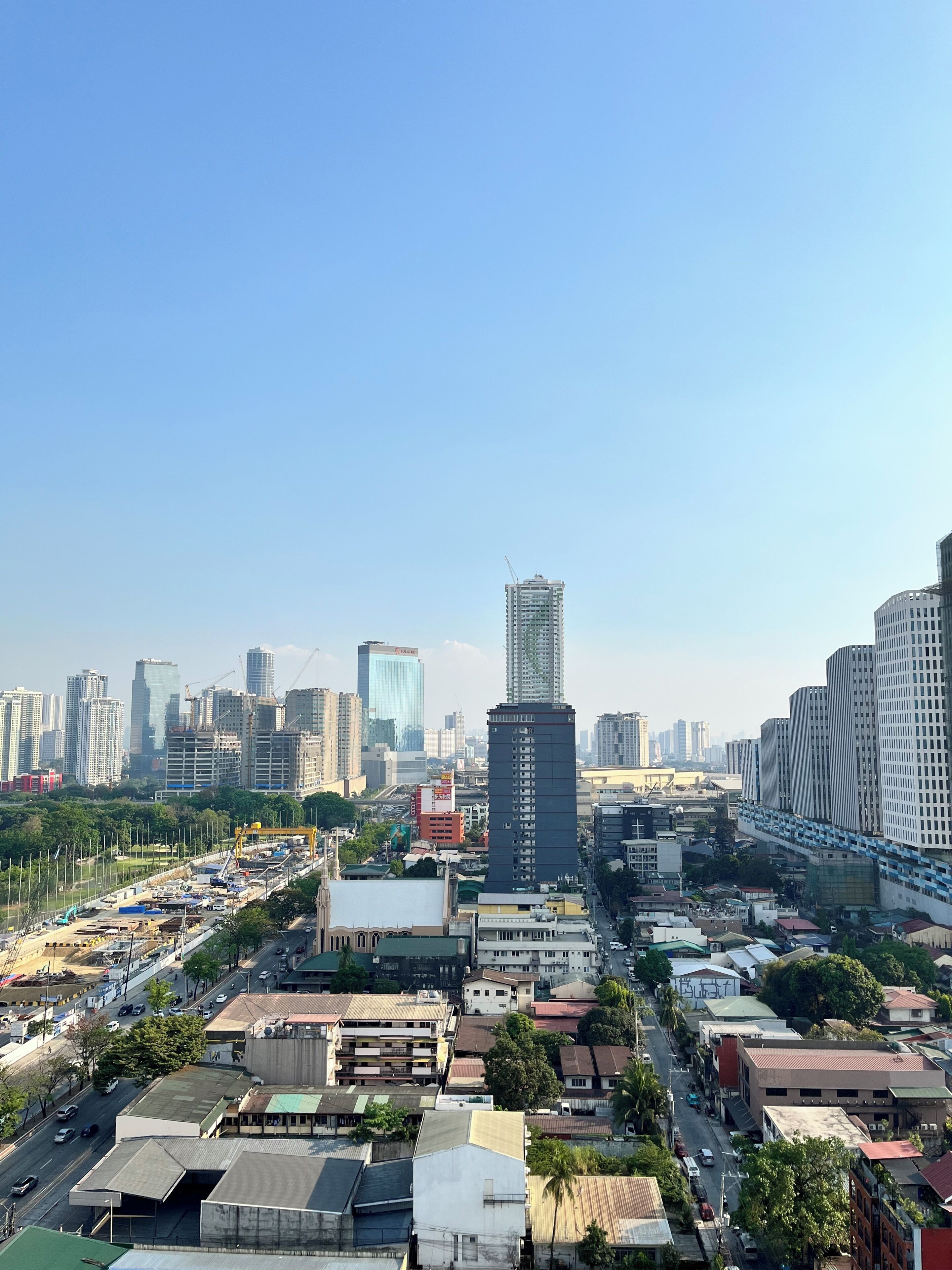A cityscape with high-rise buildings, a mix of commercial and residential structures, and a clear sky.