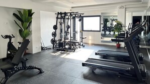 Ett gym med löpband, en viktbänk och en ställning för knäböj.