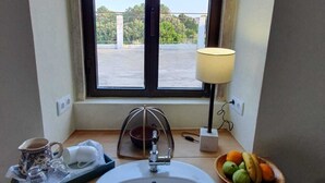 Une petite salle de bain avec une fenêtre, un lavabo et un panier de fruits.