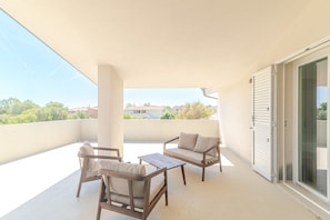 A balcony with a sofa, chairs, and a table. - Apartment 'Cala- Sea View Terrace' 150 Meters from Budoni Beach (Budoni)