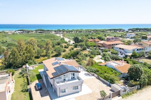 Zona residencial con casas, cielo despejado y vista al mar.