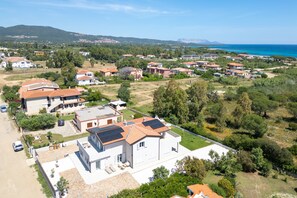 A residential area with houses, a clear sky, and a coastline in the background. - ‘Duna con Terrazza’ Apartment with Private Terrace, 3 Minutes from Budoni Beach (Budoni)