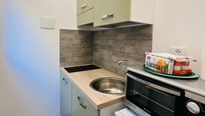A compact kitchen with a sink, a built-in oven, and a microwave. - Alpine Studio in Limone Piemonte (Limone Piemonte)