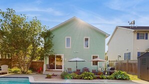 A two-story house with a swimming pool, patio furniture, and a fenced yard. - Gorgeous home with private pool - dog-friendly - only three blocks to the beach (Rehoboth Beach)