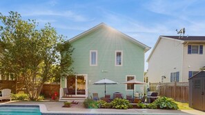 A two-story house with a swimming pool, patio furniture, and a fenced yard. - Gorgeous home with private pool - dog-friendly - only three blocks to the beach (Rehoboth Beach)