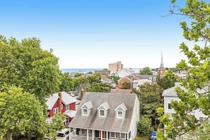 A residential area with houses, a church steeple, and a view of the ocean. - Renovated Rehoboth Beach condo with ocean-view balcony - walk to beach (Rehoboth Beach)