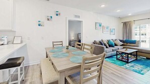 A modern living room with a dining area, a sofa set, and a coffee table. - Bayfront Condo | View, Near Lewes Beaches (Lewes)