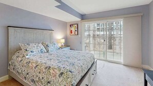 Una camera da letto con un letto, un comodino, una finestra e vista sull'esterno.