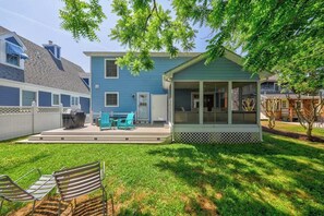 A two-story house with a covered porch, a grill, and outdoor seating. - Saltbox home near the ocean with WiFi, central AC, enclosed yard, washer/dryer (Rehoboth Beach)