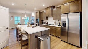 Una cocina moderna con una isla central, electrodomésticos de acero inoxidable y armarios de madera.