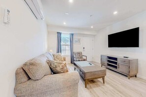 Ein modernes Wohnzimmer mit einer Couch, einem Couchtisch, einem Fernseher und einem Schrank.