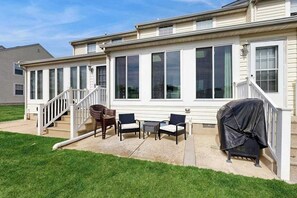 A covered patio area with outdoor furniture and a barbecue grill. - Taramino Spacious Townhouse w/shared pool, W/D & free WIFI (Lewes)