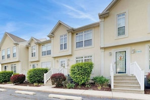 A row of townhouses with uniform architecture, front porches, and small front yards. - Taramino Spacious Townhouse w/shared pool, W/D & free WIFI (Lewes)