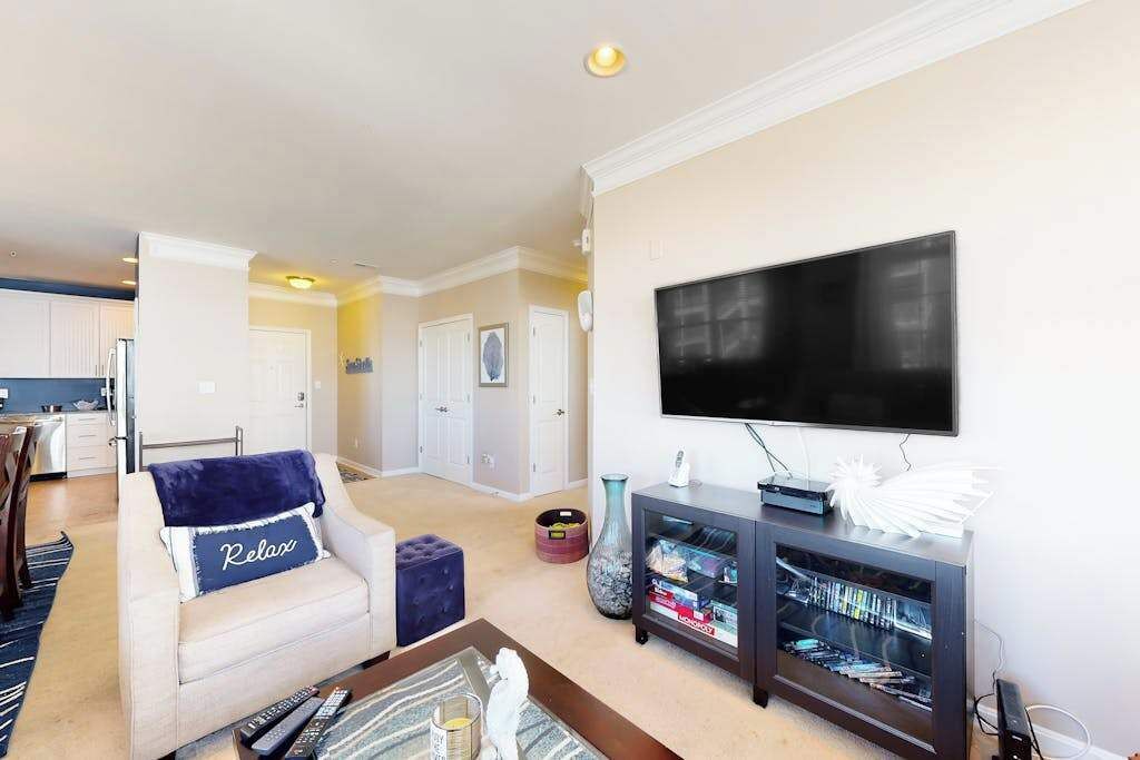A living room with a sofa, a coffee table, a TV, and a bookshelf.