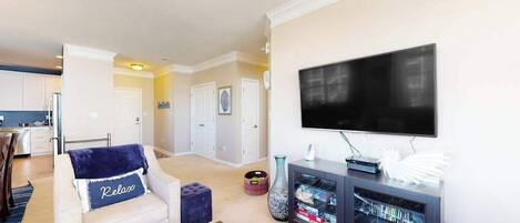 A living room with a sofa, a coffee table, a TV, and a bookshelf.