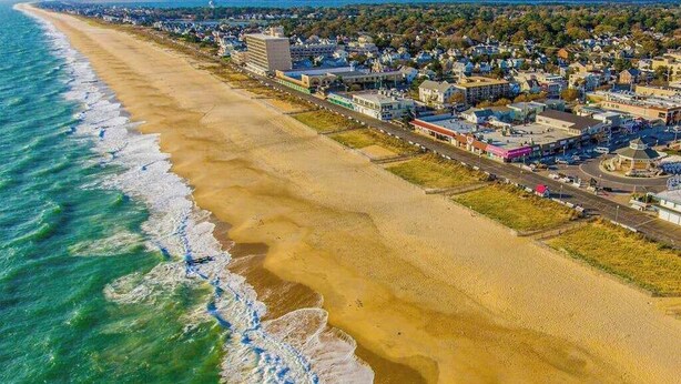 An aerial view of a coastal town with a beach, buildings, and roads. - Grande at Canal Pointe condo with pools, tennis, gym, & private balcony (Rehoboth Beach)