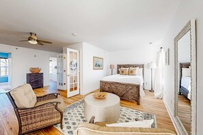 A bedroom with a bed, bedside table, lamp, and a large mirror. - Dog-friendly Villages of Five Points townhouse with pool, tennis, gym, grill (Lewes)