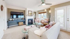 A living room with a fireplace, a sofa, a coffee table, and a television. - Town of Rehoboth Beach, Wilmington Ave #317 | Condo in Rehoboth Beach (Rehoboth Beach)