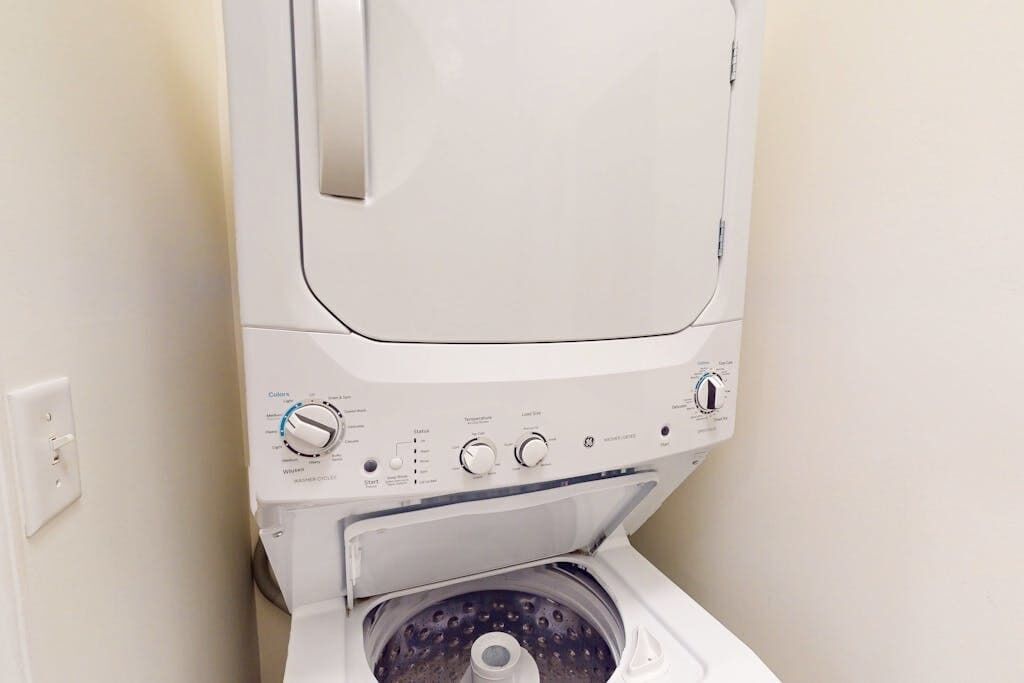 A front view of a white washing machine with control knobs and a door.