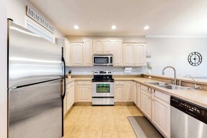 A kitchen with a stainless steel refrigerator, a microwave, an oven, and a dishwasher. - Stunning Condo- Pool and Hot Tub- Convenient Beach Access! (Rehoboth Beach)