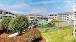 A residential building with a swimming pool, a bridge, and a small pond. - The Palms condo near the beach with on-site pool & enclosed patio (Rehoboth Beach)